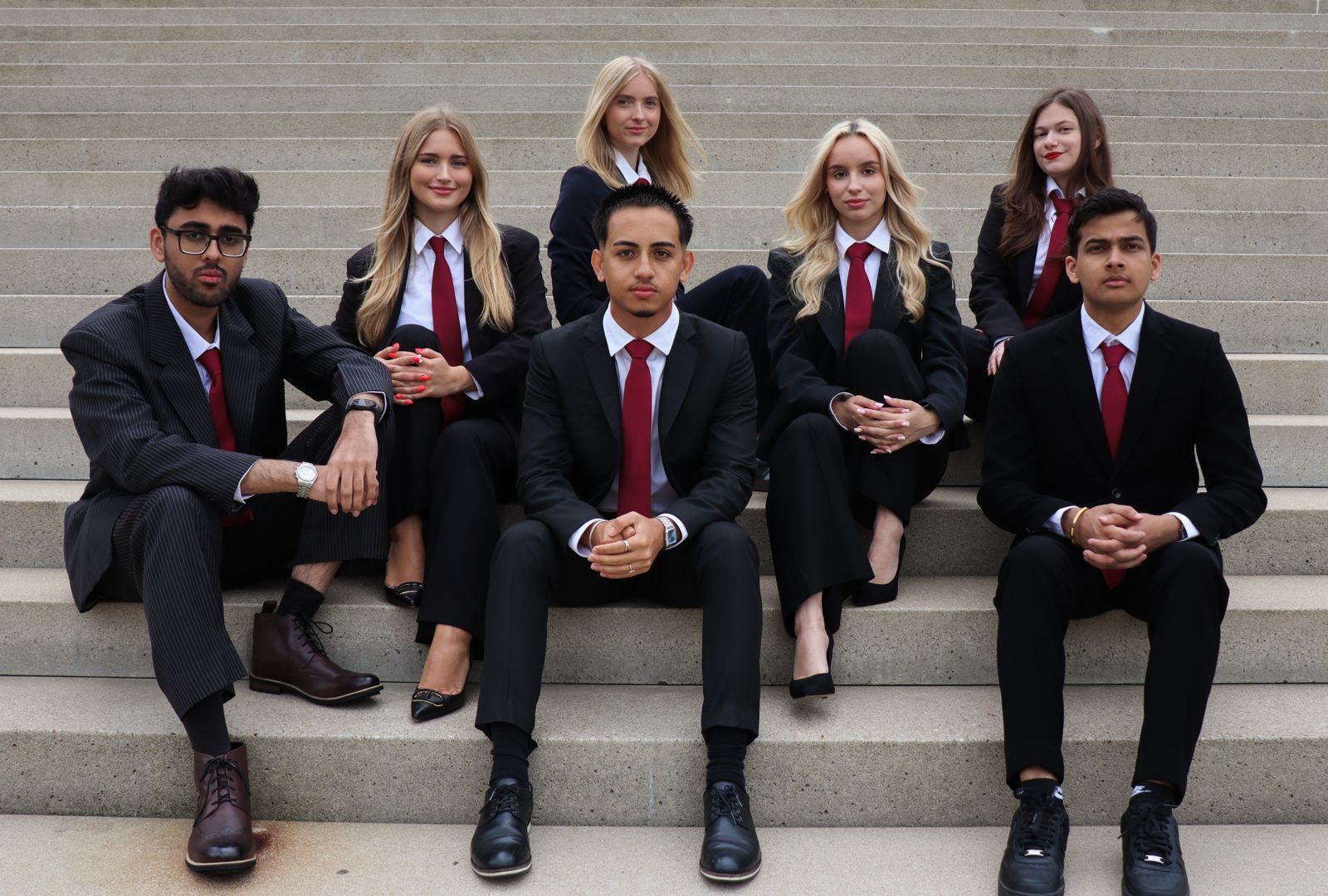 IFSA Rotterdam board members in formal attire posed on concrete stairs